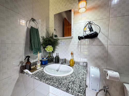 un baño con lavabo y espejo en Casa Primavera, en São Bento do Sapucaí