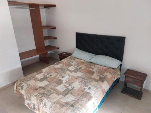 Un dormitorio con una cama con cabecero negro. en Lomas, en Santiago del Estero