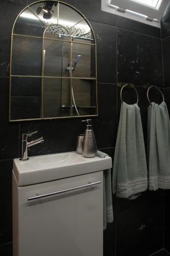 a bathroom with a sink and a mirror and towels at Foyal Toloman - Hollywood Appart in Le Lamentin