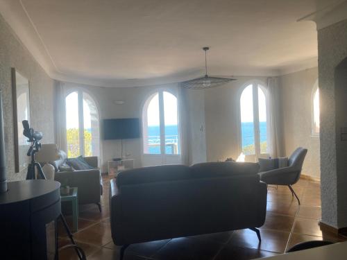 a living room with a couch and chairs and windows at Vamos a la playa - Côté mer in Cerbère