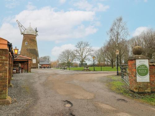 a windmill in a park with a dirt road at The Oak Room - Windmill Country Retreats in Melton Mowbray