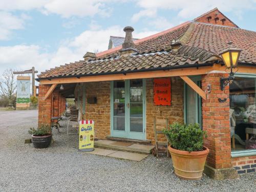 a small brick building with a sign in front of it at The Oak Room - Windmill Country Retreats in Melton Mowbray