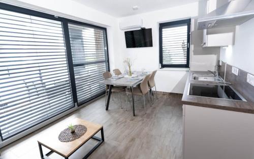 a kitchen and dining room with a table and chairs at Apartments Sunrise Banovci in Banovci