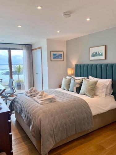 a bedroom with a large bed with a blue headboard at Endcliffe in Falmouth