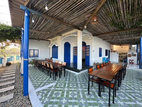 un patio con tavoli e sedie in legno in un edificio di Phước Đồng Homestay - Cù Lao Mái Nhà a Tuy An