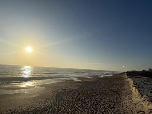 a beach with the sun rising over the ocean at Nirvana Nature's Nook in Palm Coast