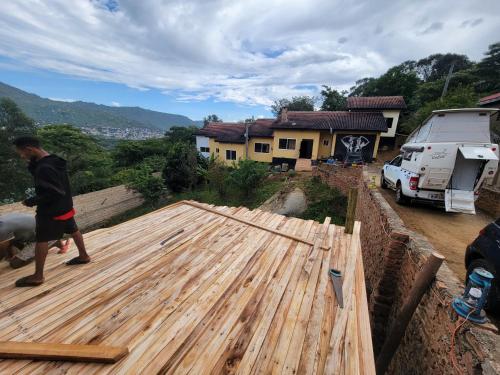 a man working on a wooden deck in front of a house at EMMY'S HIDE AWAY in Iringa
