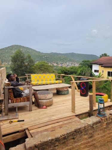 a man is sitting on a wooden deck at EMMY'S HIDE AWAY in Iringa