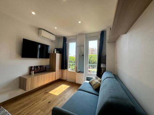 un salon avec un canapé bleu et une télévision dans l'établissement Résidence des Îles - Apt 2 Pers ultra Centre, à Antibes