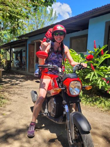 a woman is sitting on a motorcycle at Hostal Xilotl in San José del Sur