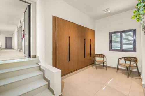 a hallway with stairs and a wooden cabinet at Boutique Hotel Bougainvillea in Kralendijk