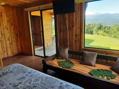a bedroom with a bed and a large window at Cabaña Vista Hermosa 6 Personas Conaripe in Panguipulli