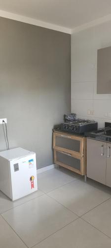 a kitchen with a stove and a box on the floor at KITNET PROX AO CENTRO - AR COND, WI-FI e ESTACIONAMENTO GRATIS in Maringá