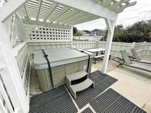 a pergola with a table and a bench on a patio at D109A- Moby Duck in Sanderling