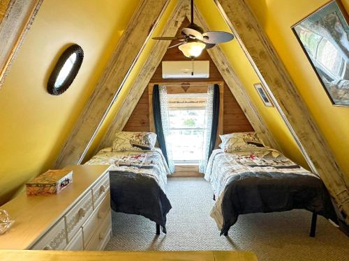 two beds in a room with yellow walls at CH307- The Pirate House in Kill Devil Hills