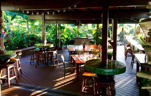 a restaurant with tables and chairs on a wooden deck at Kalani Hawaii Private Lodging in Pupukea