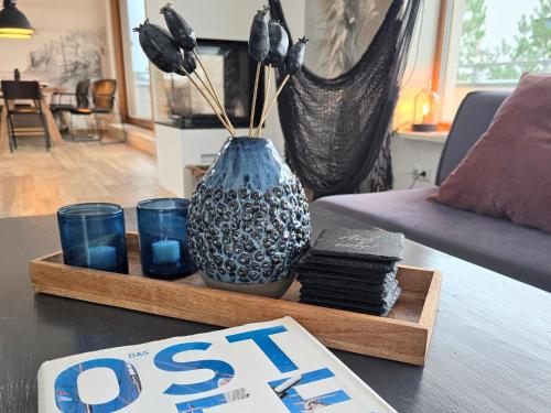 a table with a vase on a table with a book at Ferienhaus Inselliebe mit Sauna in Zempin