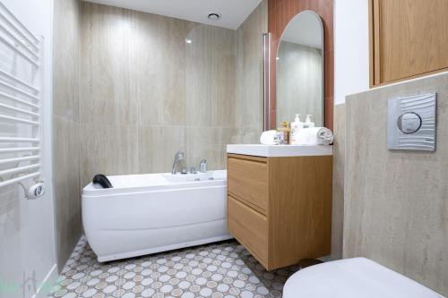 a bathroom with a tub and a sink and a toilet at Cosy air-conditioned Studio - Place de la Bourse in Bordeaux