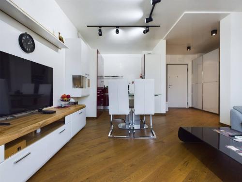 a living room with white walls and a large television at Luxury apartment in building K55 with free garage in Varna City