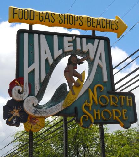 a sign for a food gas shop with a woman on a surfboard at Kalani Hawaii Private Lodging in Pupukea