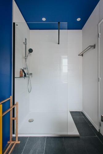 a glass shower in a bathroom with a blue ceiling at Hop Appartement d'hôtes Meursault in Meursault