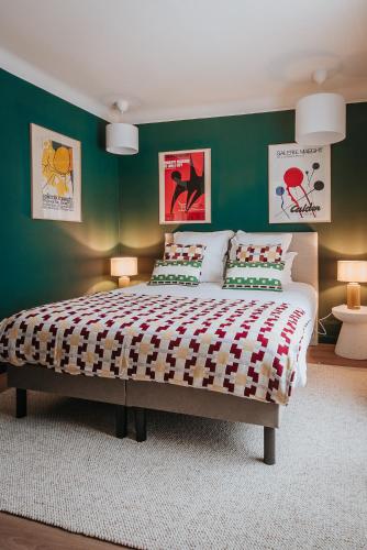 a bedroom with a large bed with green walls at Hop Appartement d'hôtes Meursault in Meursault