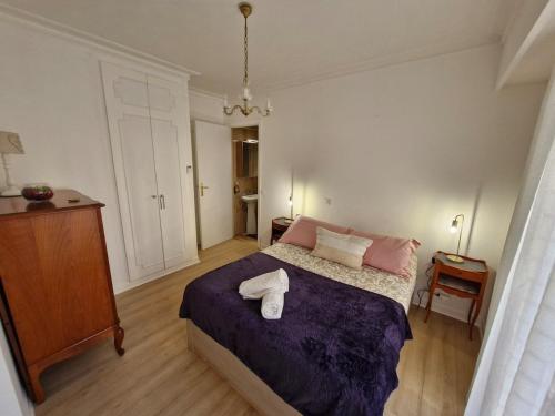 une chambre avec un lit avec une couette violette dans l'établissement Juan-Les-Pins centre, à Antibes