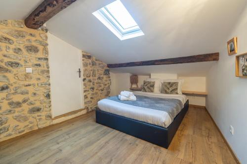 une chambre avec un lit dans un mur de pierre dans l'établissement Le Mattoni 3, à Menton