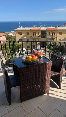 a table with a plate of fruit on a balcony at LEDA Apartaments in Taormina