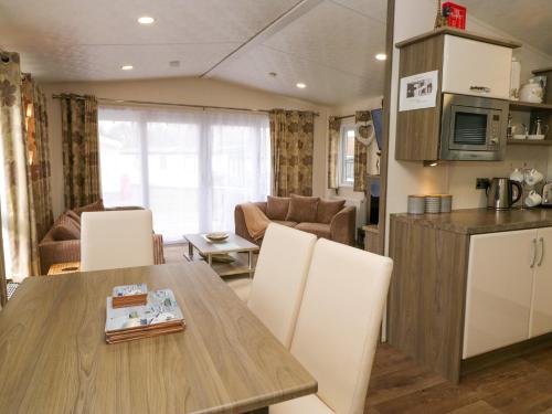 a kitchen and living room with a table and chairs at 3 Yealands in Carnforth