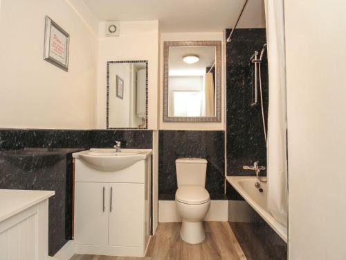 Un baño con inodoro, lavabo y bañera. en Seagulls Nest, en Bridport