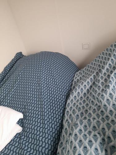 - un lit avec une couette bleue et un oreiller dans l'établissement Mobilhome neuf pour 6 personnes Mer et Vacances, à Leffrinckoucke