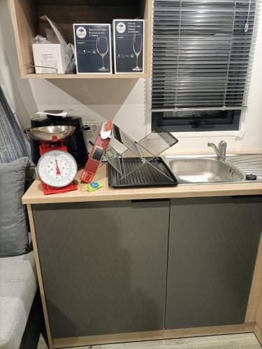 - un comptoir de cuisine avec un pèse-personne et un évier dans l'établissement Mobilhome neuf pour 6 personnes Mer et Vacances, à Leffrinckoucke