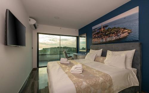 ein Schlafzimmer mit einem großen Bett mit einem großen Fenster in der Unterkunft Villa Eligo mit 2 Whirlpools, Meerblick, Pool und Fitnessraum in Premantura