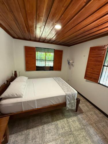 a bedroom with a large bed with a wooden ceiling at Hacienda Baru in Dominical
