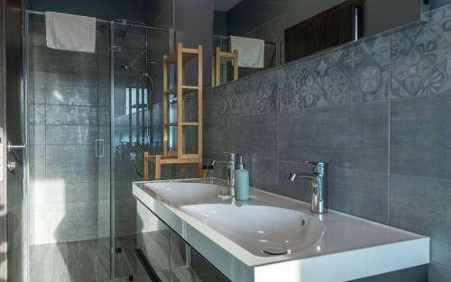 ein Badezimmer mit Waschbecken und Glasdusche in der Unterkunft Villa Eligo mit 2 Whirlpools, Meerblick, Pool und Fitnessraum in Premantura