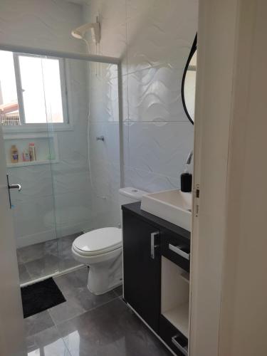 Un baño con inodoro, lavabo y ducha. en Casa perto da Praia do Laranjal, en Pelotas