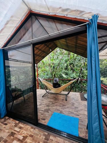 a man sleeping in a hammock in a tent at Garza del Sol Glamping Bromelia in San Rafael