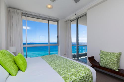 a bedroom with a bed with a view of the ocean at Points North Apartments in Gold Coast