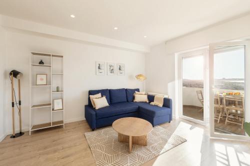 a living room with a blue couch and a table at Baleal Blue Sky in Ferrel