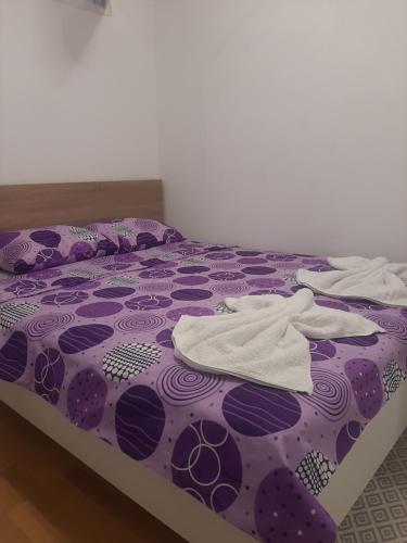 a purple bed with white towels on top of it at Luxury Lamela Bulevar in Sarajevo