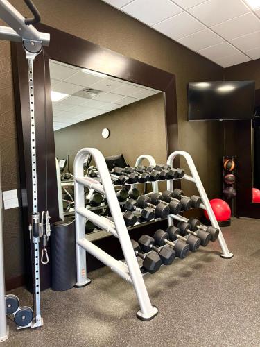 a room with a gym with a rack of weights at Kozy Hotel Houston North in Westfield