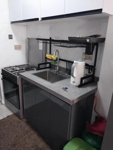 a kitchen with a sink and a stove at Hellen's Condo in Nairobi