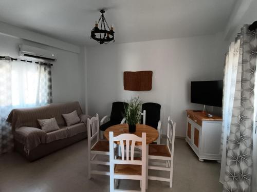 a living room with a table and a couch at Embrujo Andaluz Complejo Rural Órgiva in Órgiva
