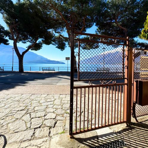 a metal gate with a view of the water at Vista Lago - Lake Como collection in Domaso
