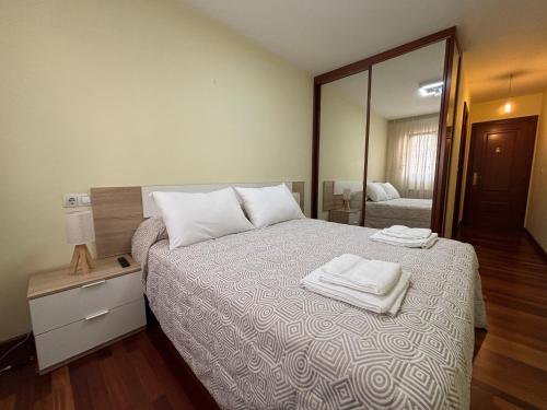a bedroom with a bed with two towels on it at Apartamento Ribeira Sacra in Monforte de Lemos
