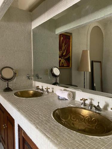a bathroom with two sinks and a large mirror at Hacienda del Lago Boutique Hotel in Ajijic