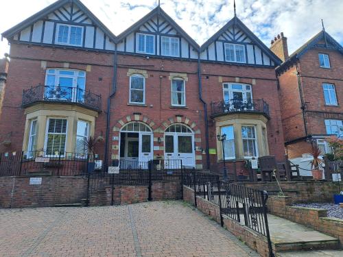 a large brick building with white doors and windows at Aaron Accommodation in Whitby