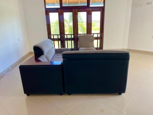 a blue couch in a room with a window at Kamatha Hotel & Restaurant in Ambalantota