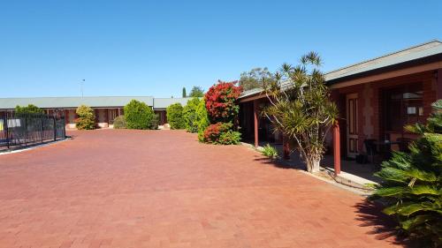 una entrada de ladrillo rojo junto a un edificio con plantas en Gateway Motor Inn, en Broken Hill